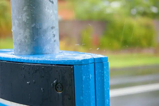 The moment a water droplet breaks upon impacting a bus stop sign.