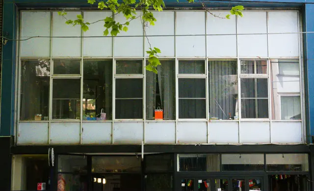 A straight-on shot of a building facade. Right in the middle, a red paper bag. It says &ldquo;MYER&rdquo;